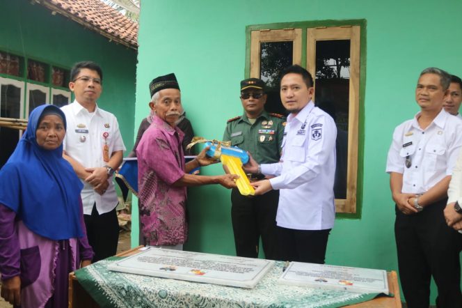 
 Wabup Lampura Ardian Saputra saat menyerahkan kunci rumah secara simbolis bantuan bedah rumah dari Kodim 0412/LU, Rabu 1 Februari 2023. Foto IST ---